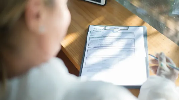 Woman filling out forms for open enrollment 2027 health insurance premiums