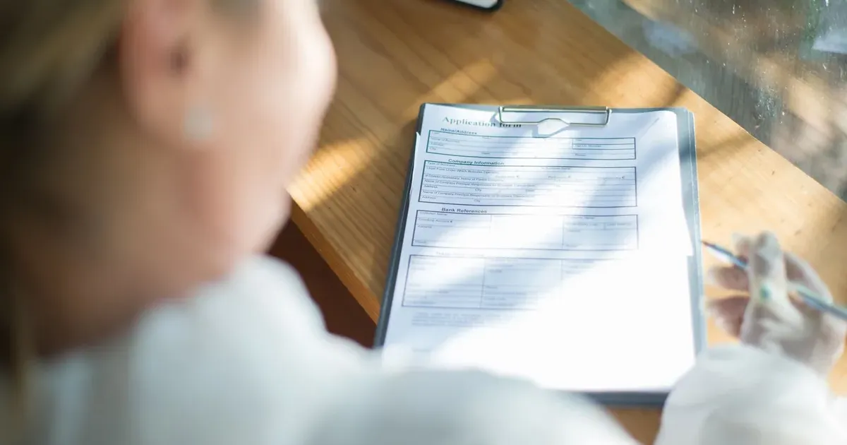 Woman filling out forms for open enrollment 2027 health insurance premiums