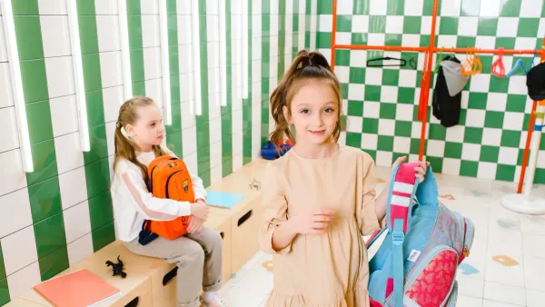 Child holding a backpack while shopping for back-to-school supplies during a tax-free weekend