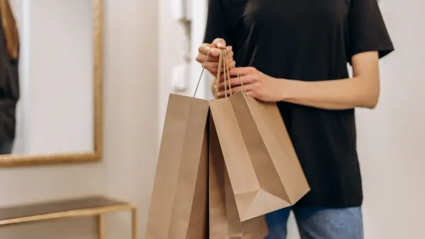 Teenager carrying shopping bags and a backpack after a back-to-school shopping trip