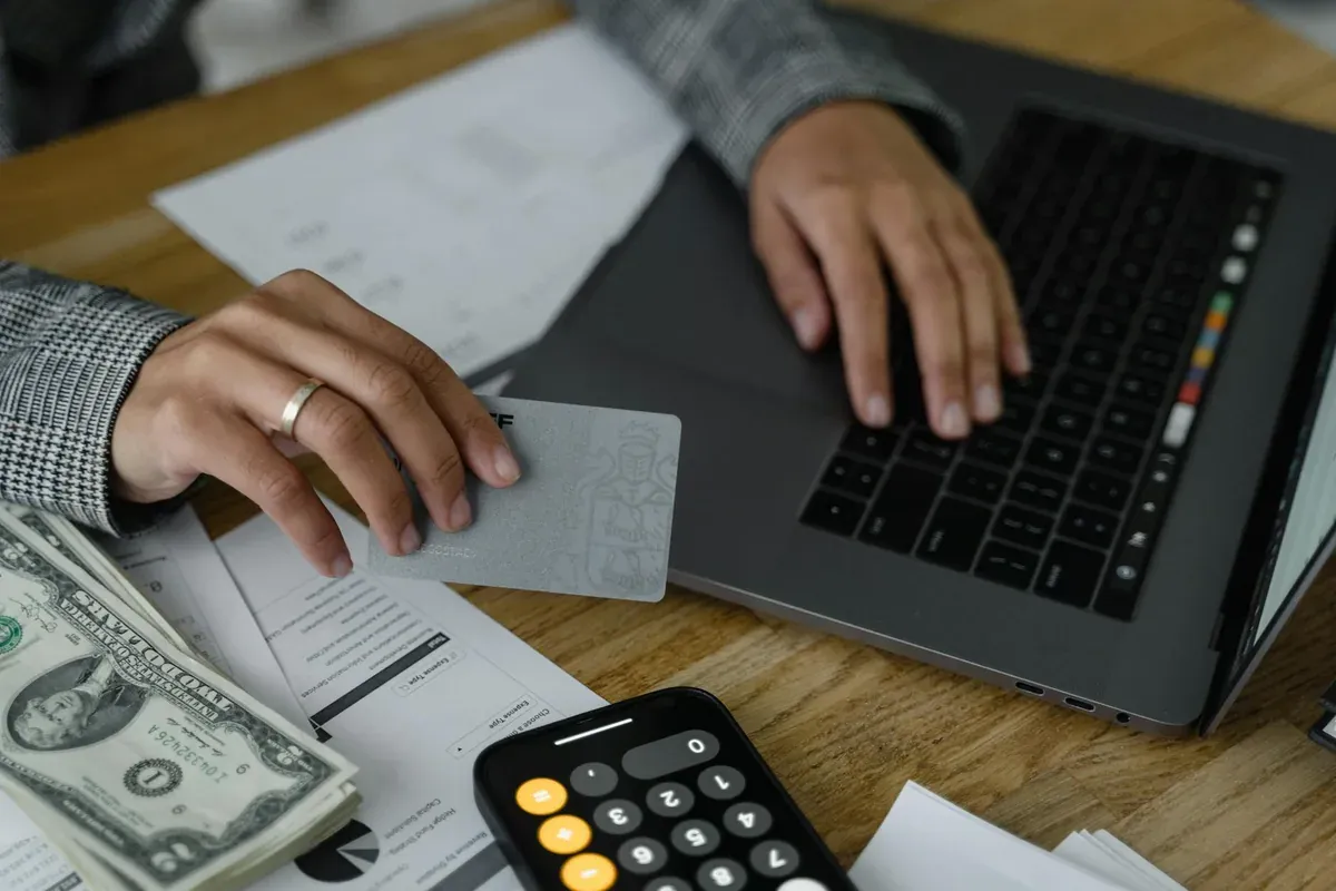 Person reviewing credit card and financial statements at desk — managing BNPL and buy now pay later debt