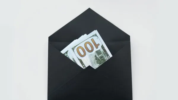Cash bills and money envelopes on a desk — cash vs card spending psychology