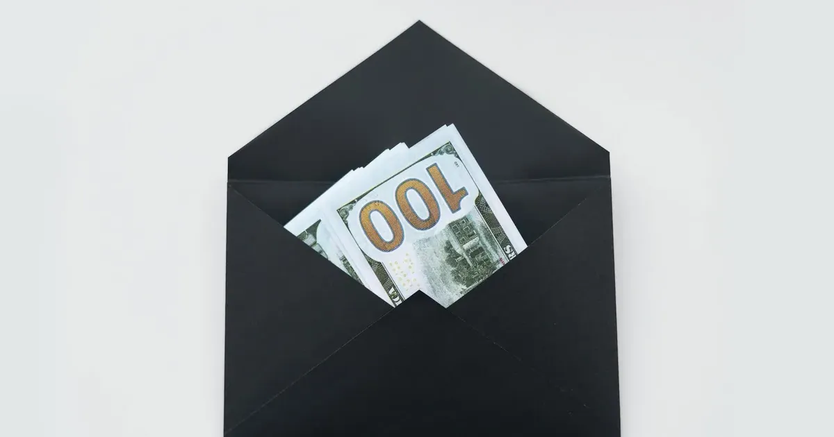 Cash bills and money envelopes on a desk — cash vs card spending psychology