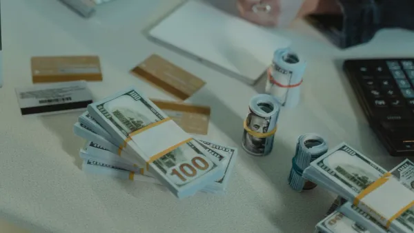 Rolled dollar bills and credit cards on a desk — comparing CD vs high yield savings rates in 2026