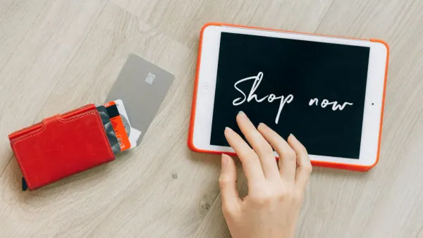 Close-up of credit cards next to a digital tablet on a table, representing debt settlement decisions