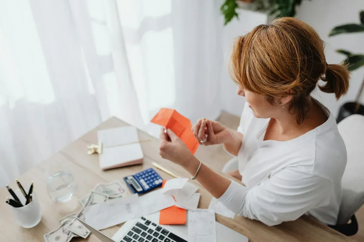 Woman working at a desk reviewing her home savings budget on a laptop