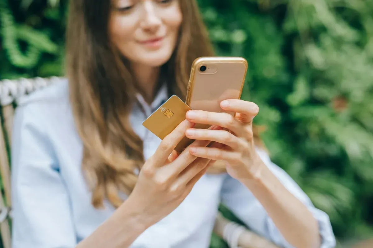 A woman reviewing her savings plan on her phone, tracking emergency fund progress