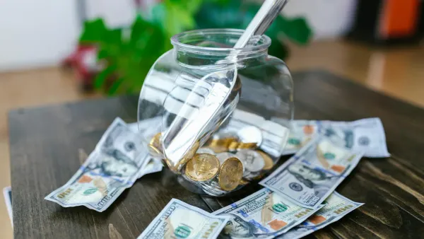 Glass jar filled with dollar bills representing an emergency fund savings goal