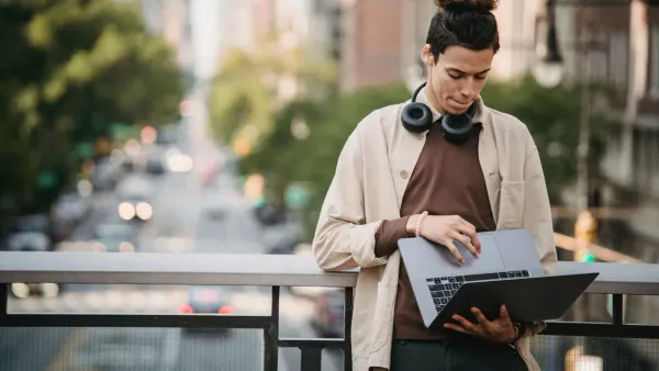 Gen Z professional setting up first job budget on laptop in apartment 2026