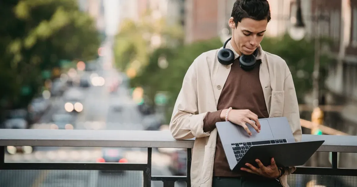 Gen Z professional setting up first job budget on laptop in apartment 2026
