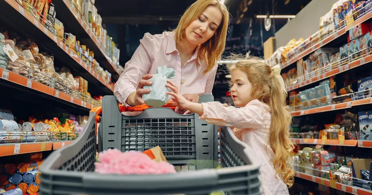 Family grocery shopping in a supermarket, illustrating how to manage a grocery budget in 2026