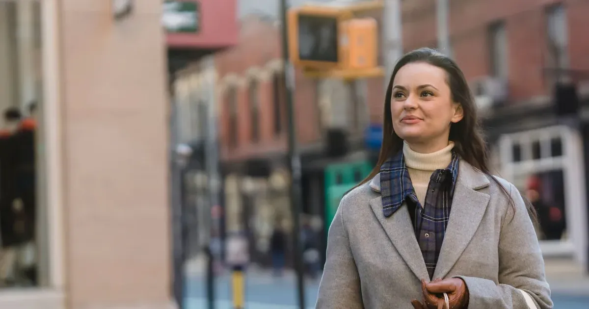 Shopper with gift bags on a city street planning a holiday gift budget for 2026