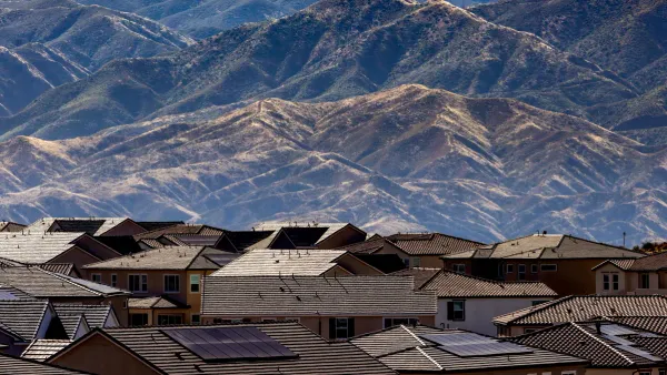 Aerial view of a suburban American neighborhood with dry mountains behind it, representing rising home insurance costs in 2026