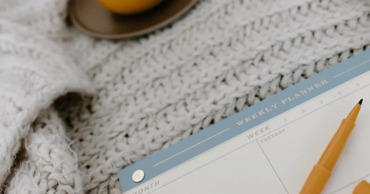 Desk with a planner and calendar used to plan 2027 HSA and FSA open enrollment contributions