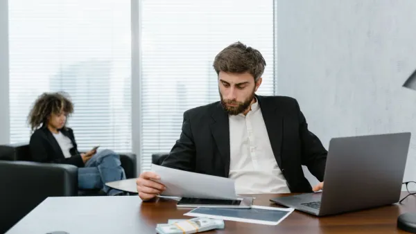 Person reviewing financial documents and reports at a desk — mid-year money audit