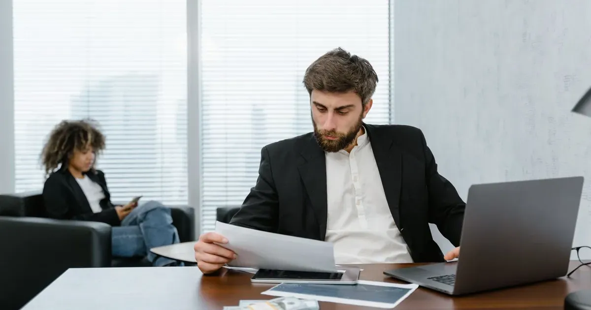 Person reviewing financial documents and reports at a desk — mid-year money audit