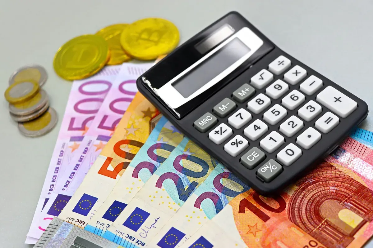 Τετράδιο, κομπιουτεράκι και ευρώ πάνω σε γραφείο, υπολογισμός προϋπολογισμού φροντιστηρίου