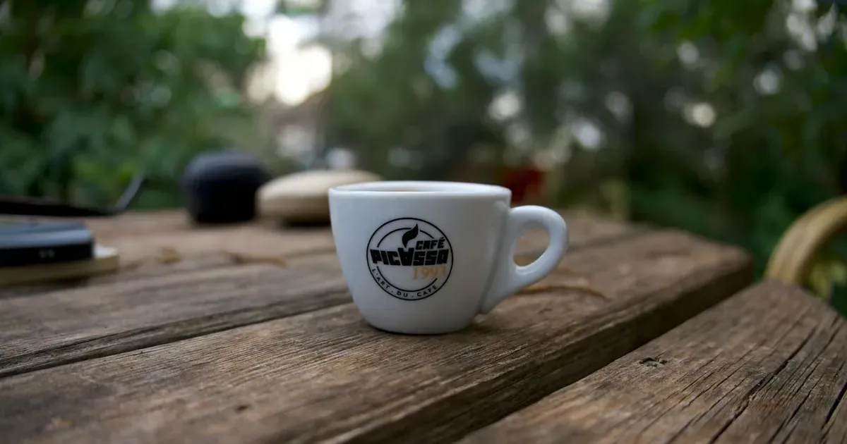 Φλιτζάνι espresso σε ξύλινο τραπέζι εξωτερικού χώρου — μικρές καθημερινές δαπάνες και αποταμίευση