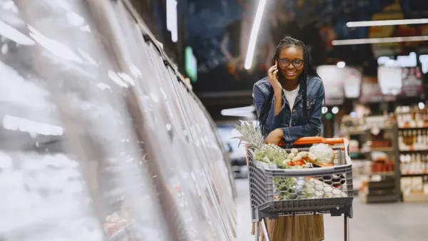 Woman shopping in a grocery store aisle, illustrating rising US grocery costs against wage growth in 2026