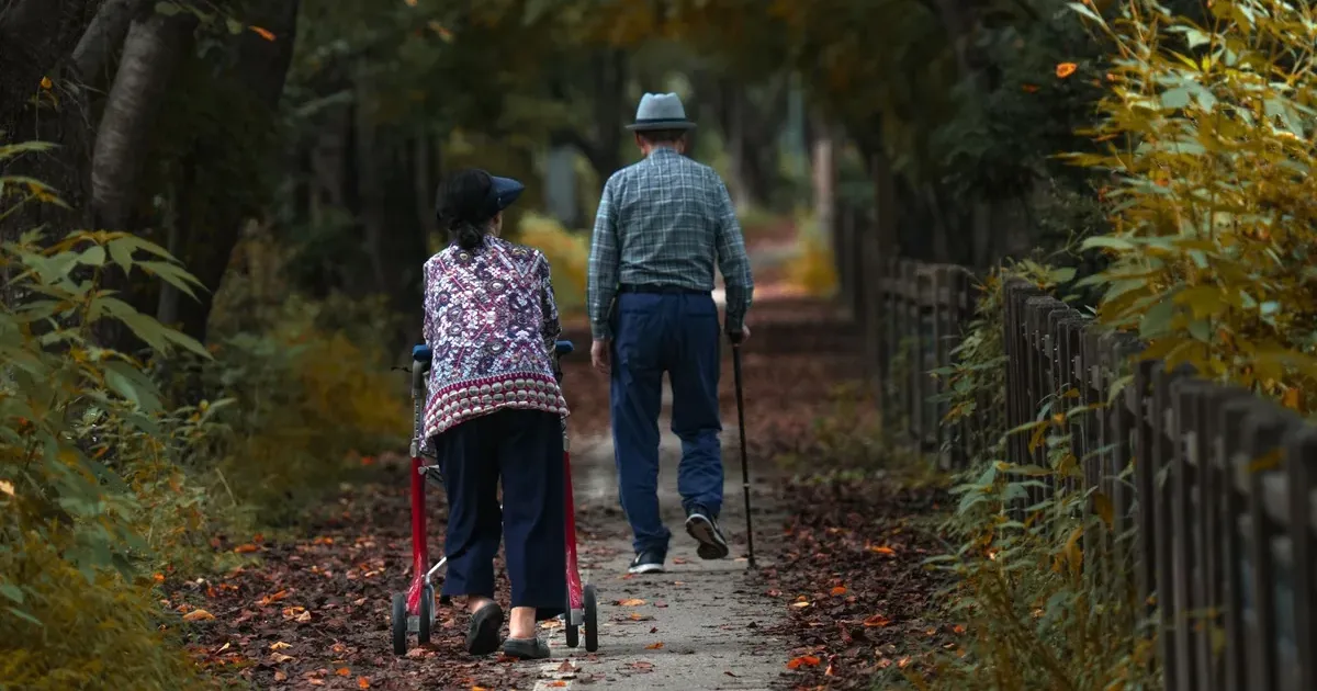 Senior couple walking together on an autumn path, representing retirees planning for the 2027 Social Security COLA