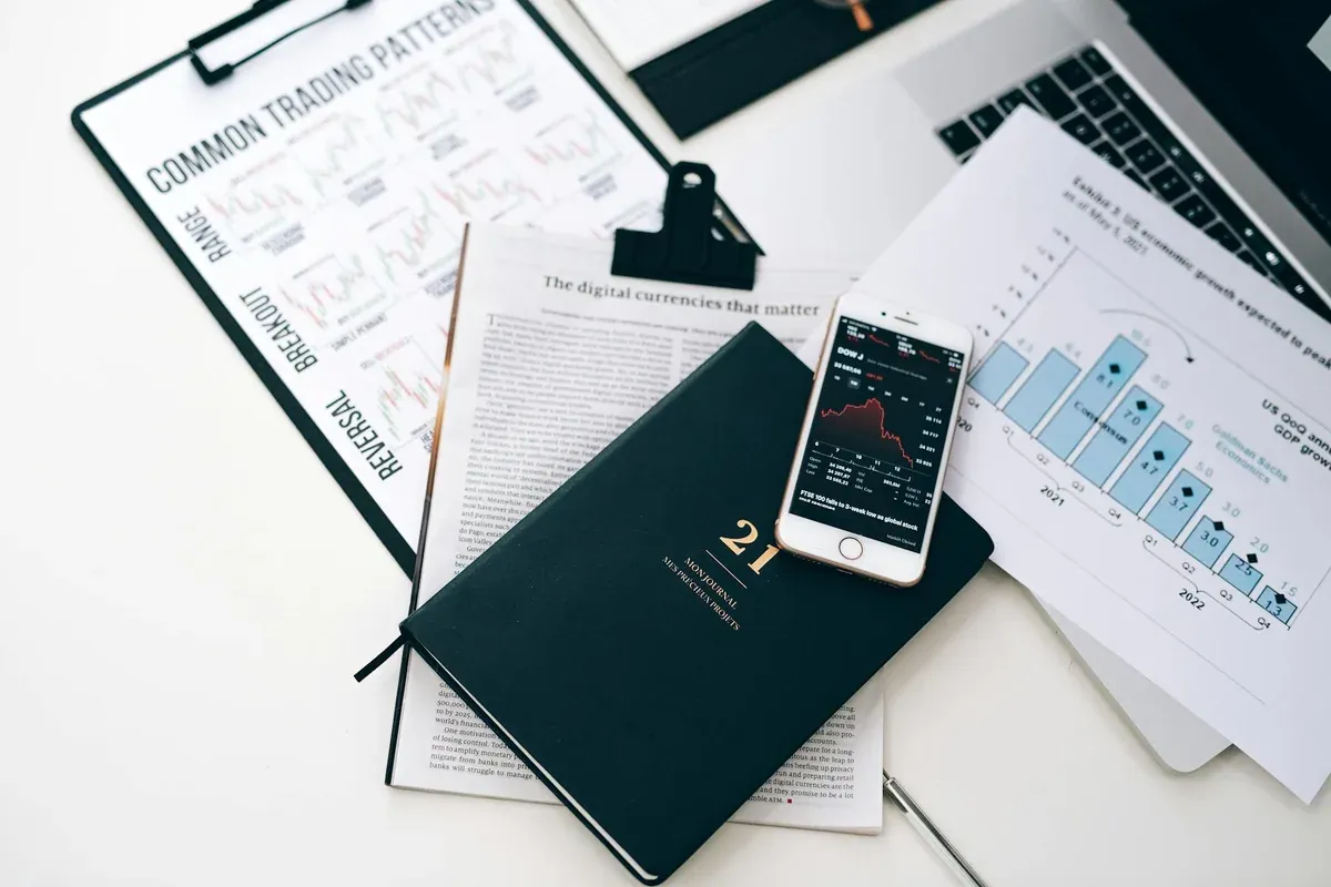 Financial planning notebook and printouts on a white desk, representing the conscious budgeting approach between soft saving and FIRE