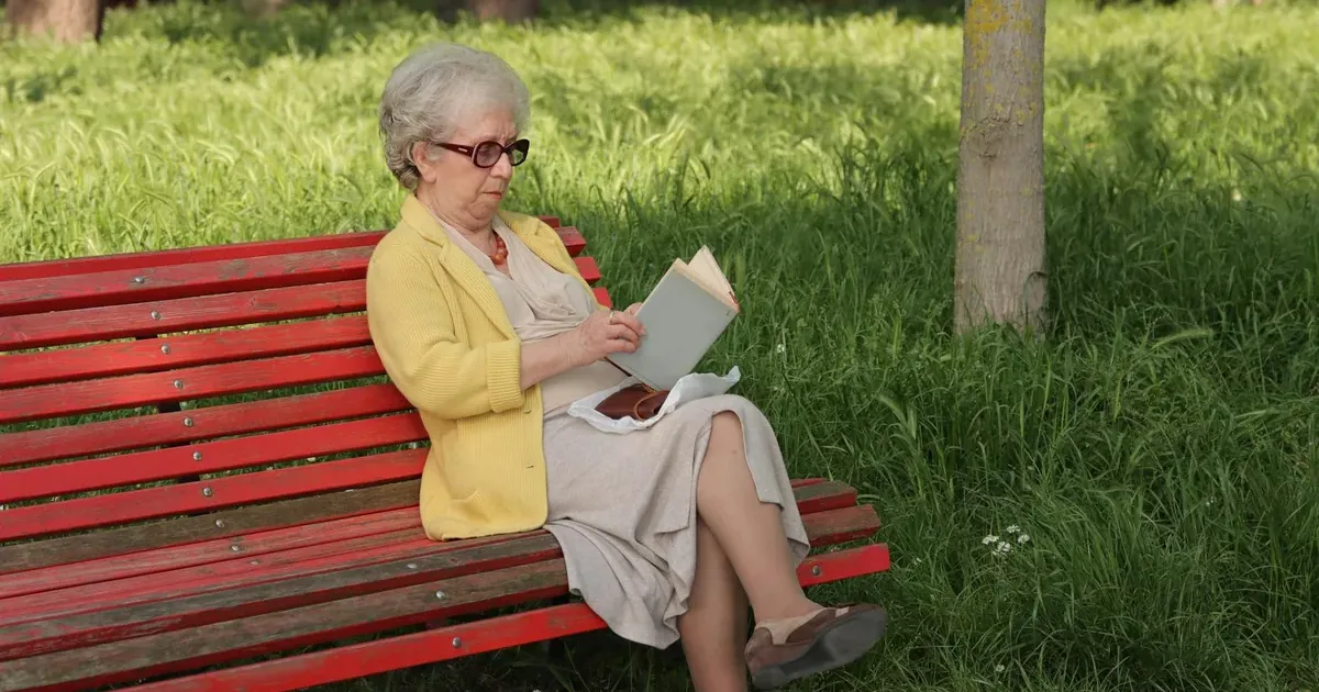 Person relaxing outdoors on a park bench, representing the soft saving lifestyle and work-life balance