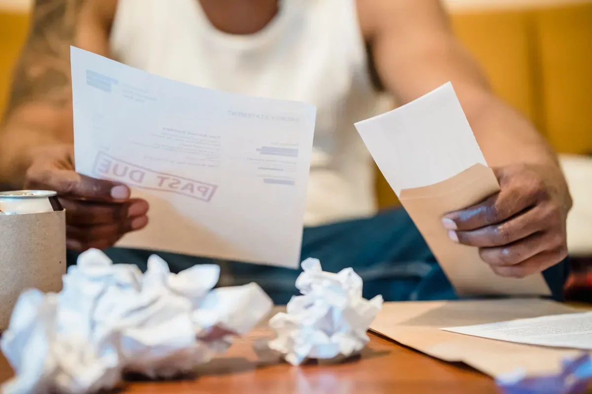 Person reviewing student loan bills and statements at a desk