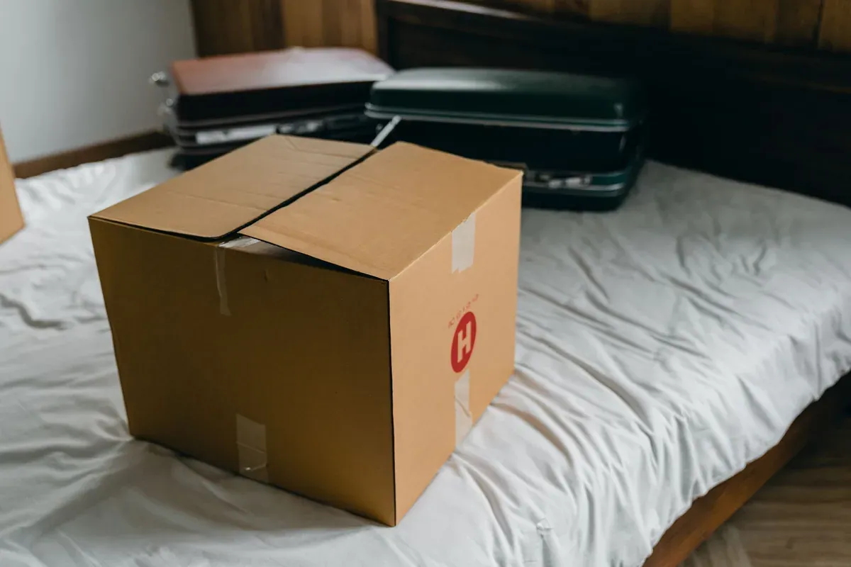 Suitcase and packed clothes laid out on a bed, representing travel planning for wedding season