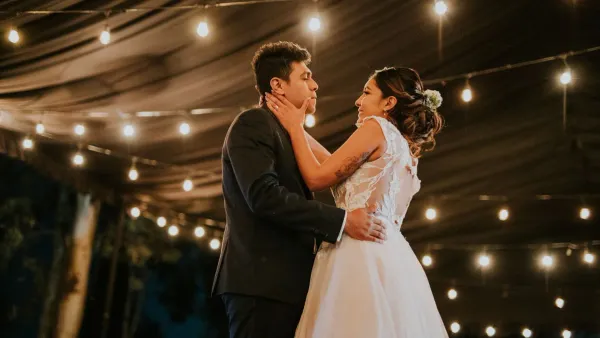 Wedding reception venue lit with string lights at dusk, representing wedding guest budget costs