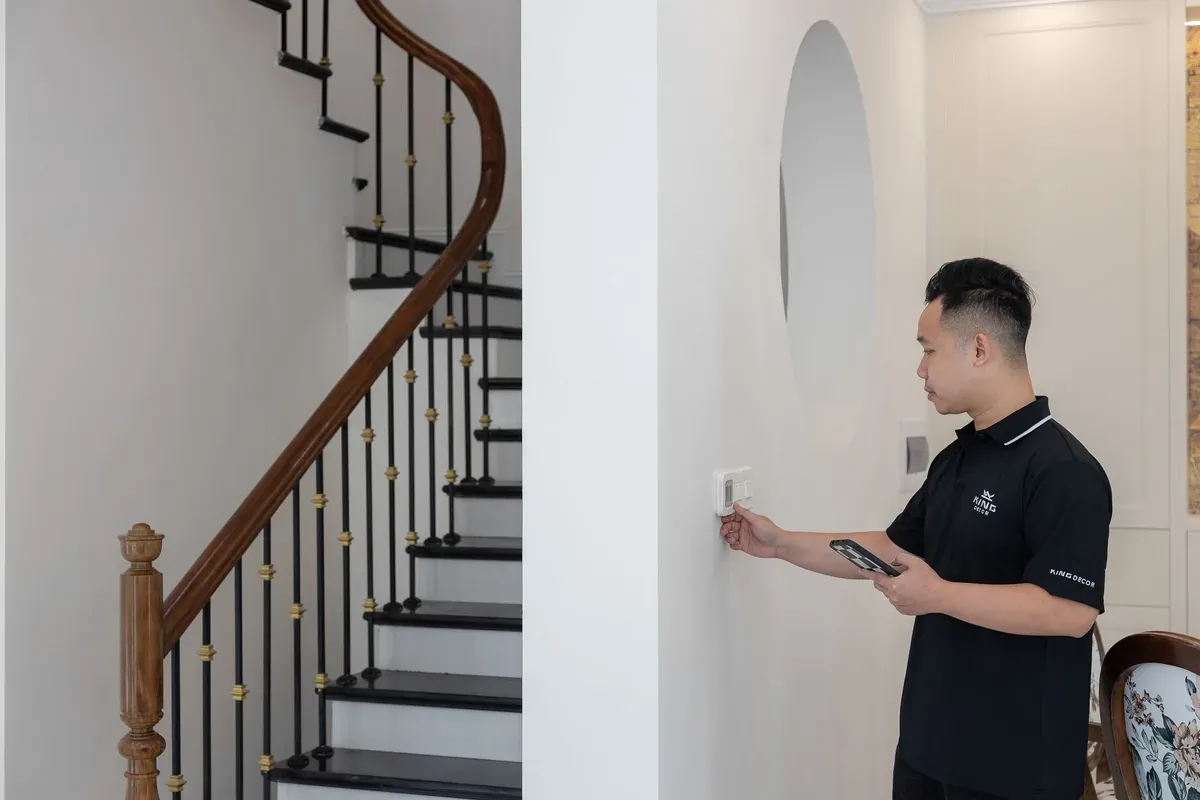 Hand adjusting a wall thermostat to manage a winter heating budget